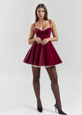 Red wine velvet mini dress featuring a fitted bodice and sheer detail, showcasing an elegant silhouette and soft texture.