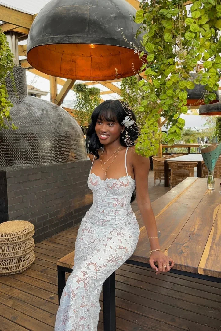 Women's white lace maxi dress with fitted design and spaghetti straps, featuring intricate lace patterns and a flowing…