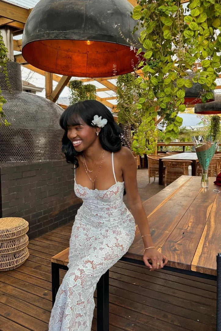 Women's white lace maxi dress with fitted design and spaghetti straps, featuring a delicate floral pattern and soft lining.