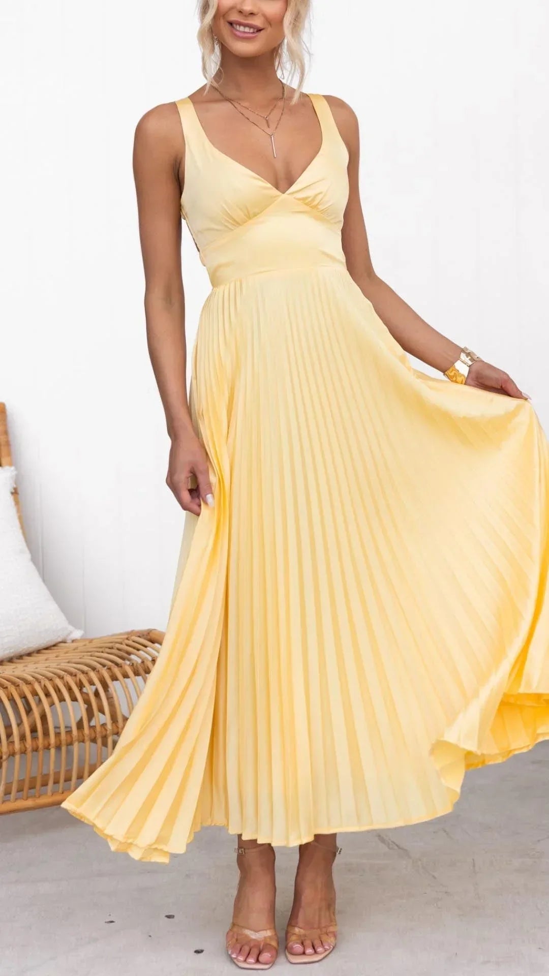 Women’s yellow pleated maxi dress featuring a v-neckline, wide straps, and lightweight fabric, perfect for warm weather.